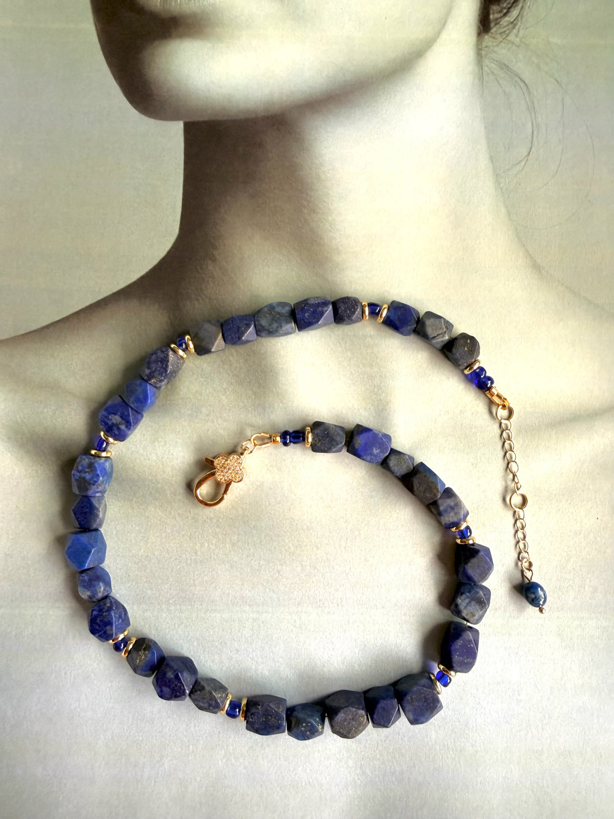 TNT Designs Jewels Lapis Lazuli beaded necklace with faceted blue stones, gold spacers, and crystal-embellished clasp.