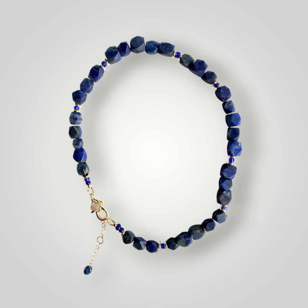 TNT Designs Jewels lapis lazuli beaded necklace with faceted blue stones, gold spacers, and crystal-embellished clasp.