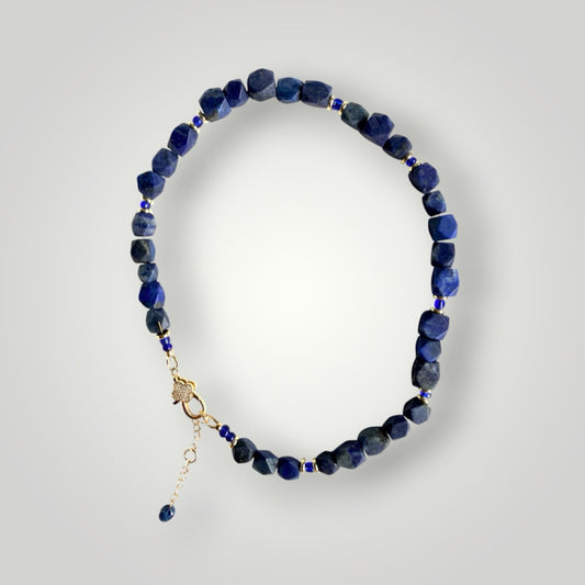 TNT Designs Jewels lapis lazuli beaded necklace with faceted blue stones, gold spacers, and crystal-embellished clasp.